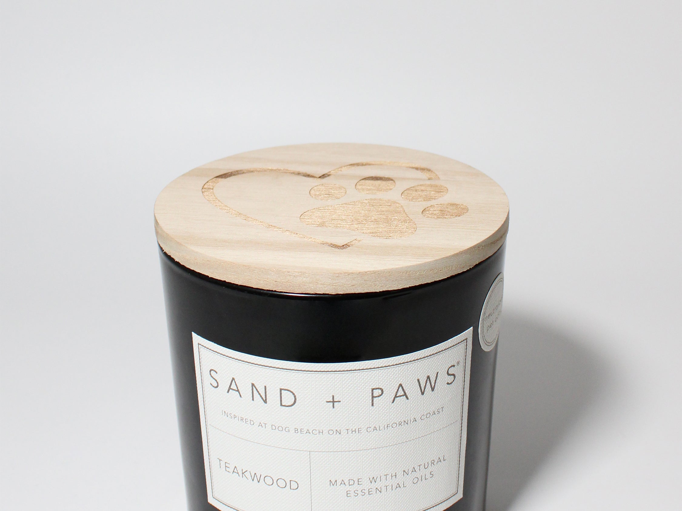 Sand + Paws Teakwood 21 oz scented candle Black vessel with Paw in Heart lid