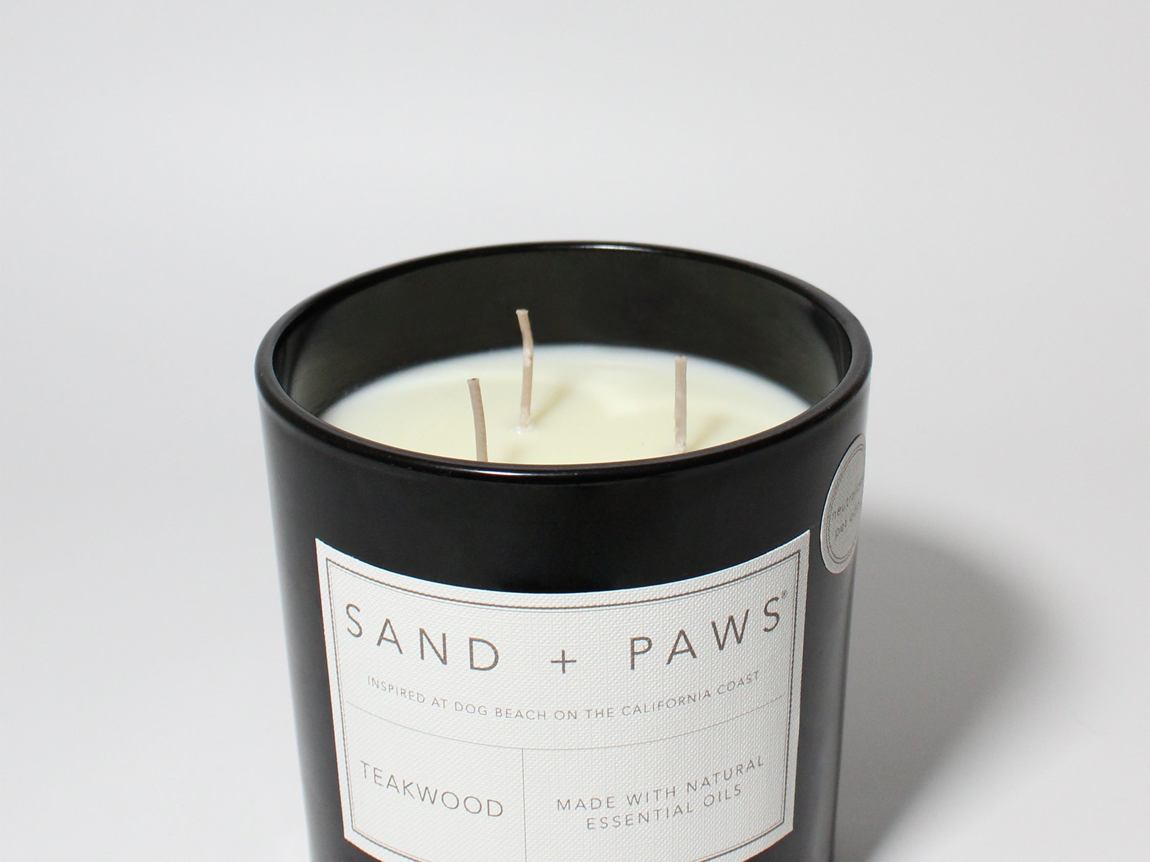 Sand + Paws Teakwood 21 oz scented candle Black vessel with Paw in Heart lid