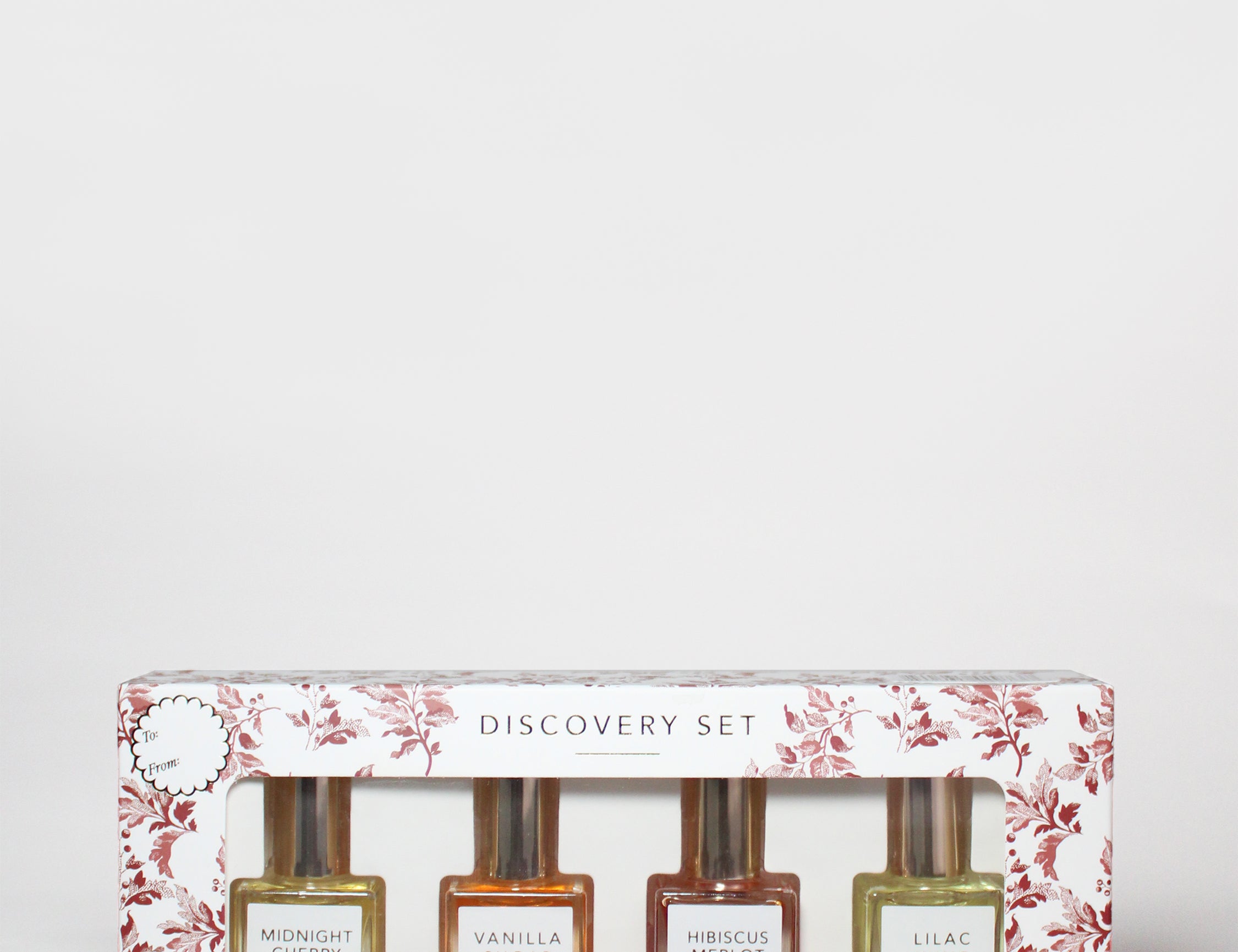 Perfume oil rollerball discovery set box with four bottles and floral print