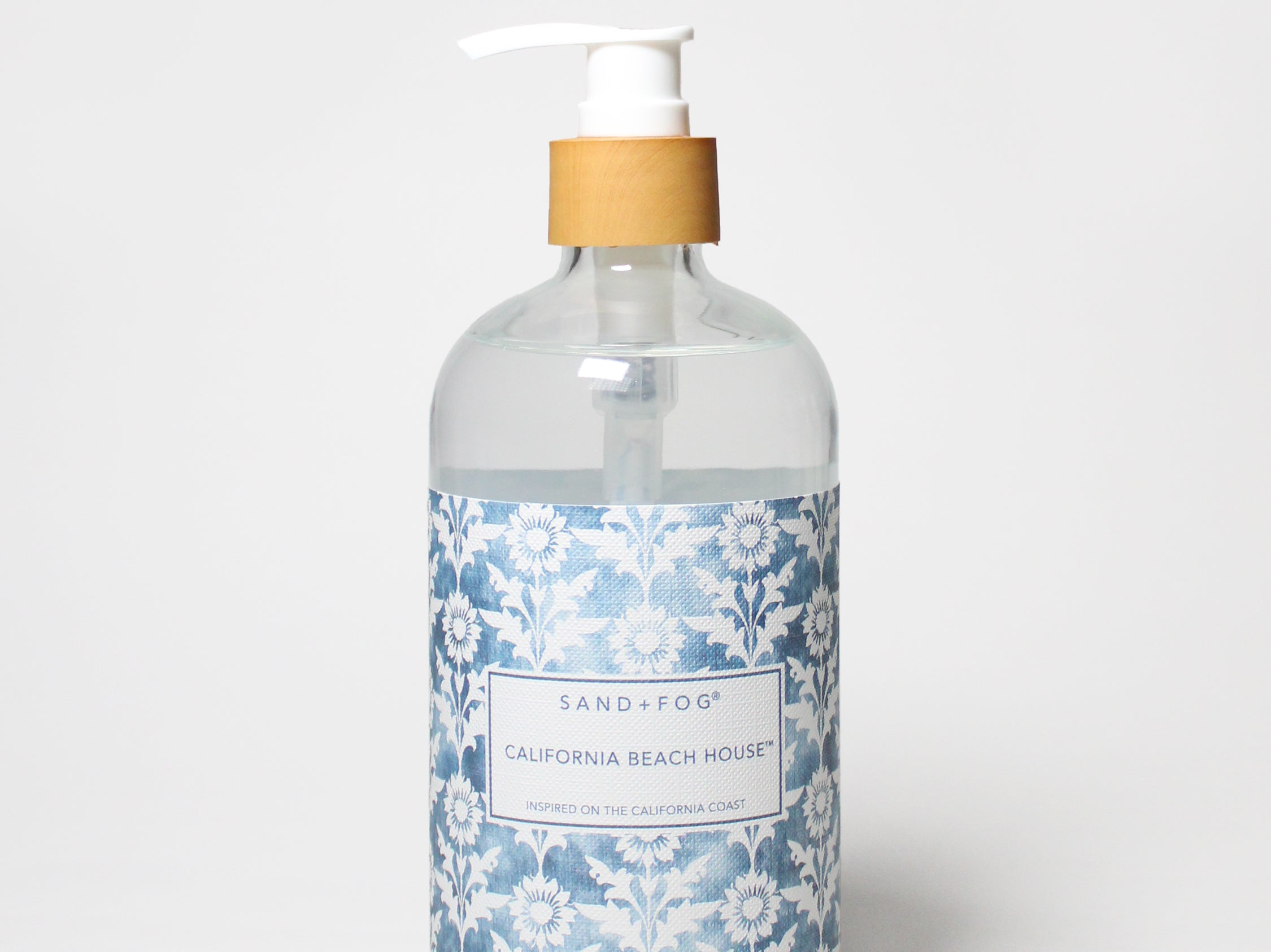 Liquid hand soap bottle with clear glass, beige pump, blue floral label