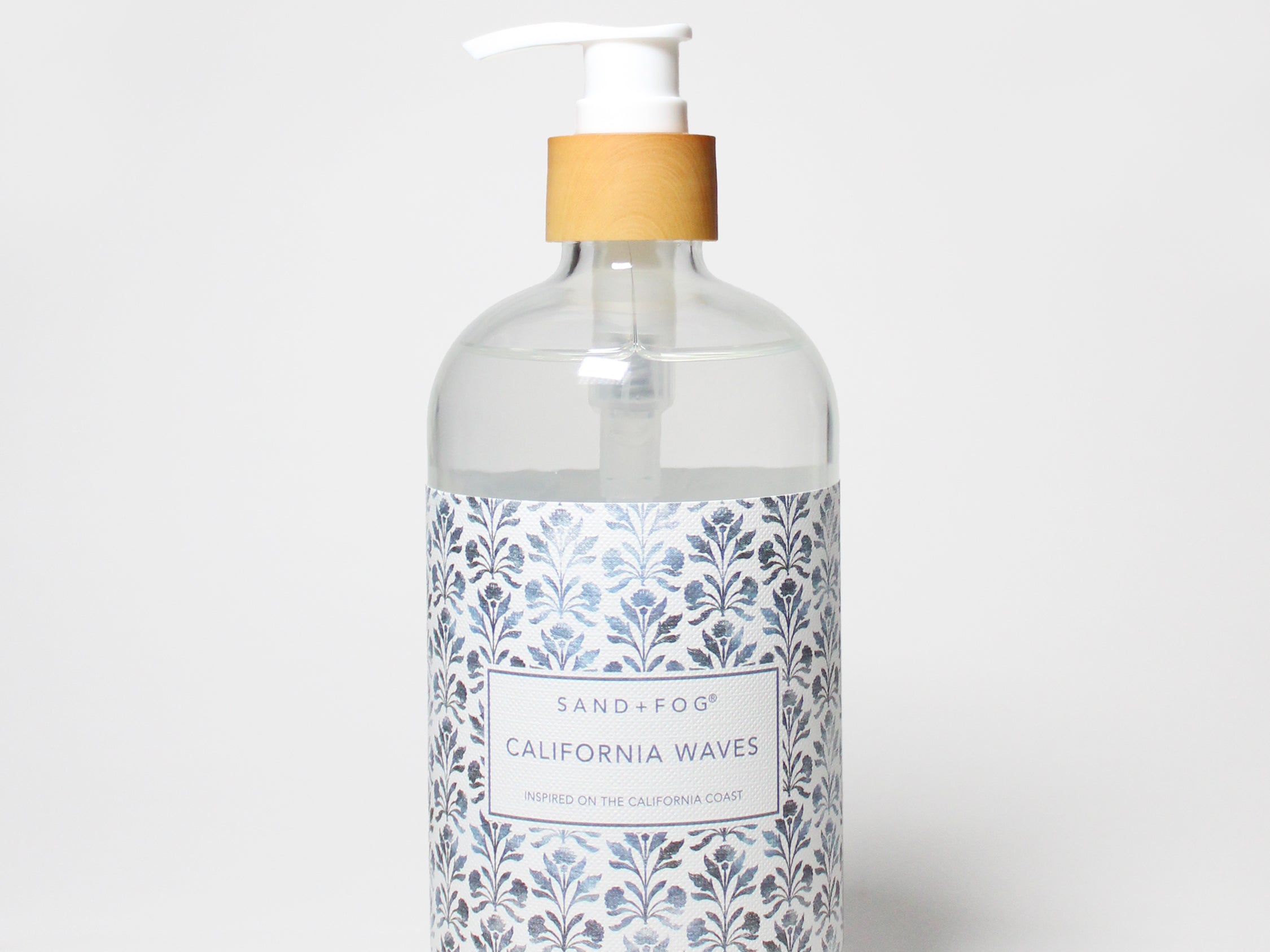 Clear liquid hand soap bottle with white pump and blue patterned label