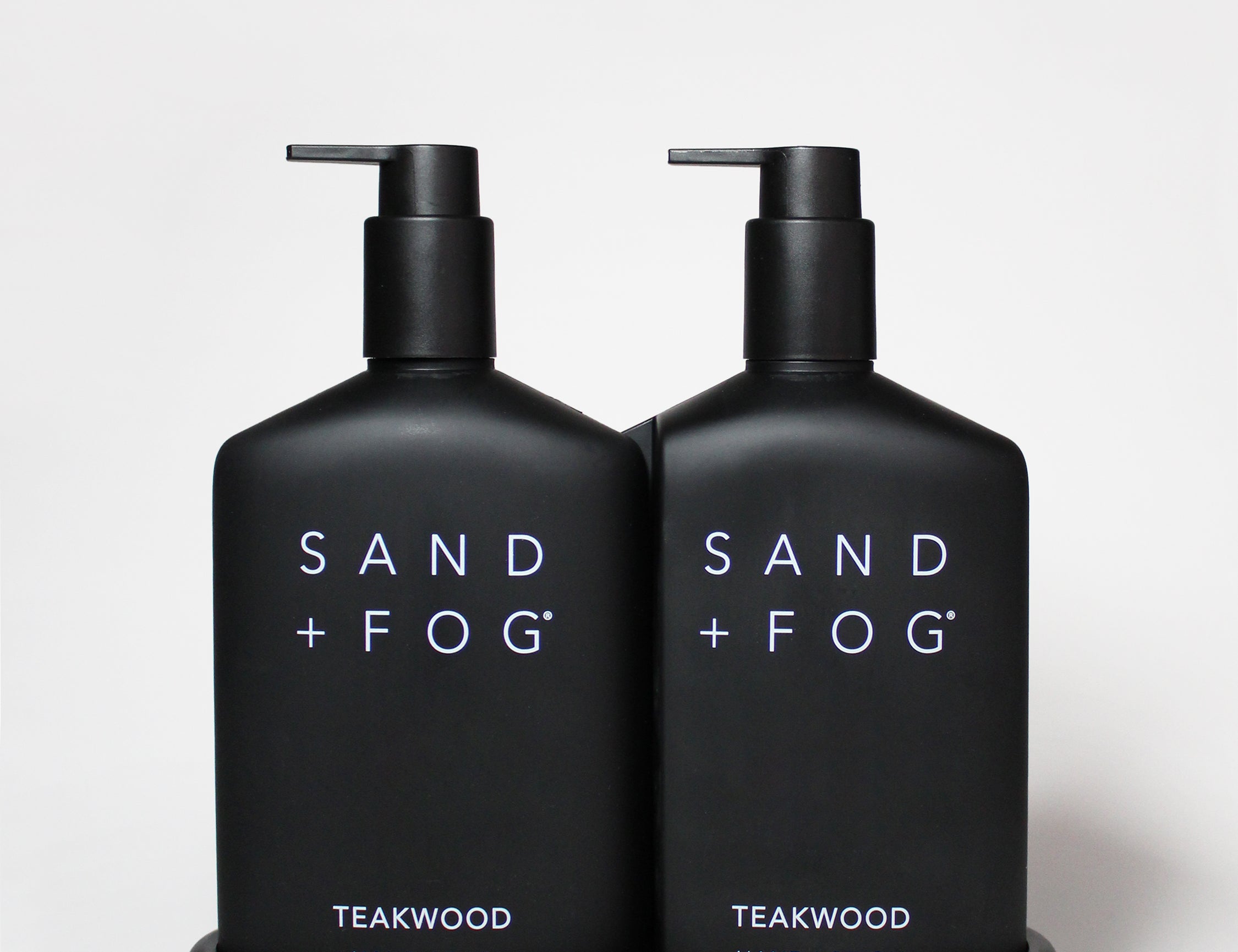 Teakwood hand soap and hand lotion set in black pump bottles on a matching tray