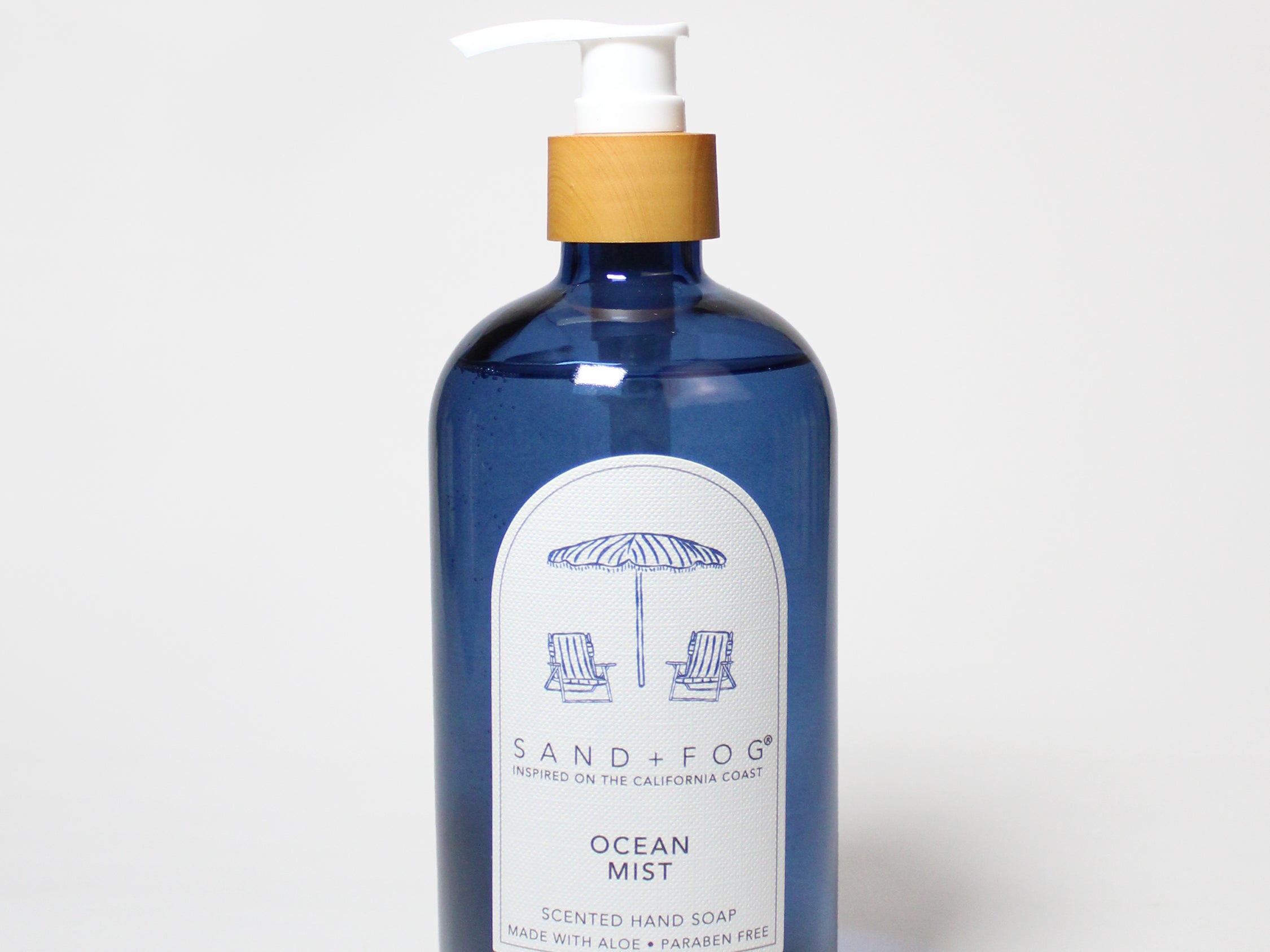 Dark blue liquid hand soap bottle with gold pump and Ocean Mist label