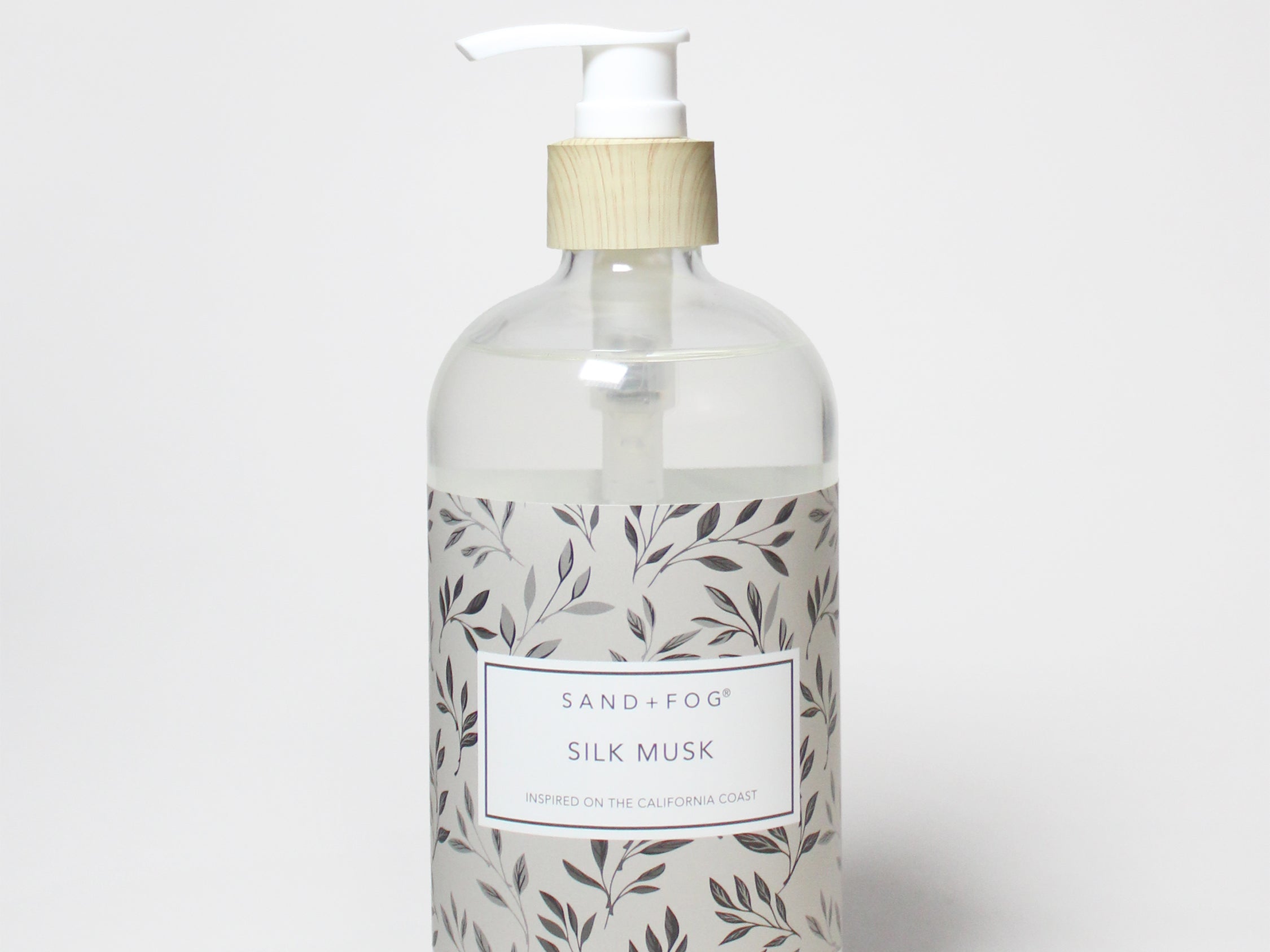 Liquid hand soap bottle with white pump and leaf-pattern label, beige top