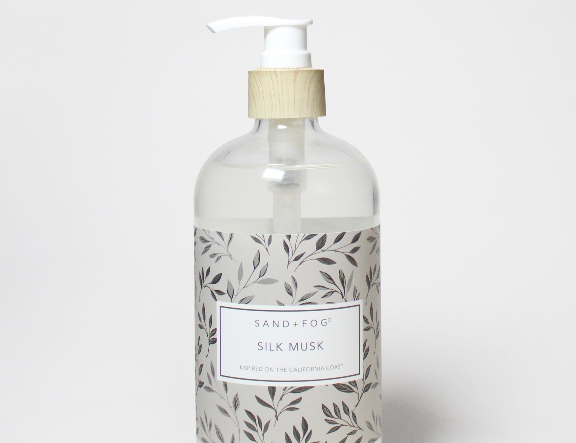 Liquid hand soap bottle with white pump and leaf-pattern label, beige top