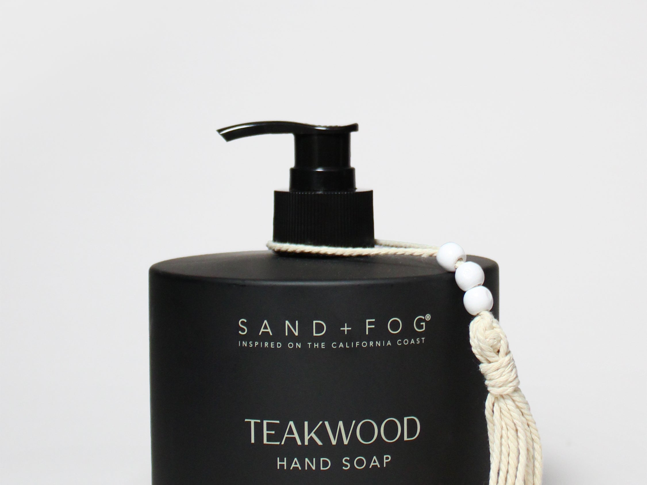 Black liquid hand soap bottle with pump; Teakwood scent, Sand+Fog branding, tassel