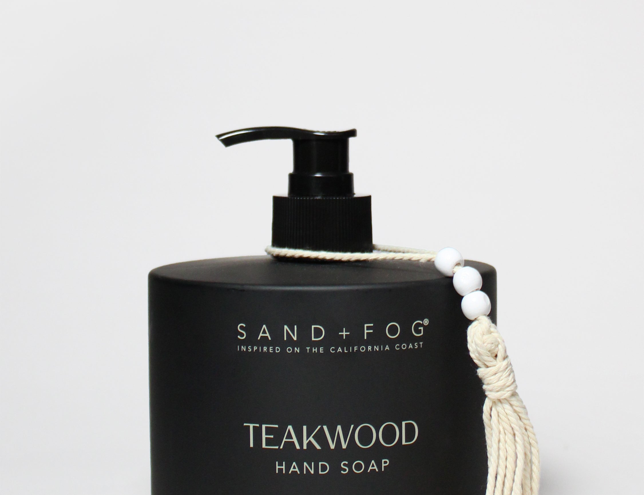 Black liquid hand soap bottle with pump; Teakwood scent, Sand+Fog branding, tassel