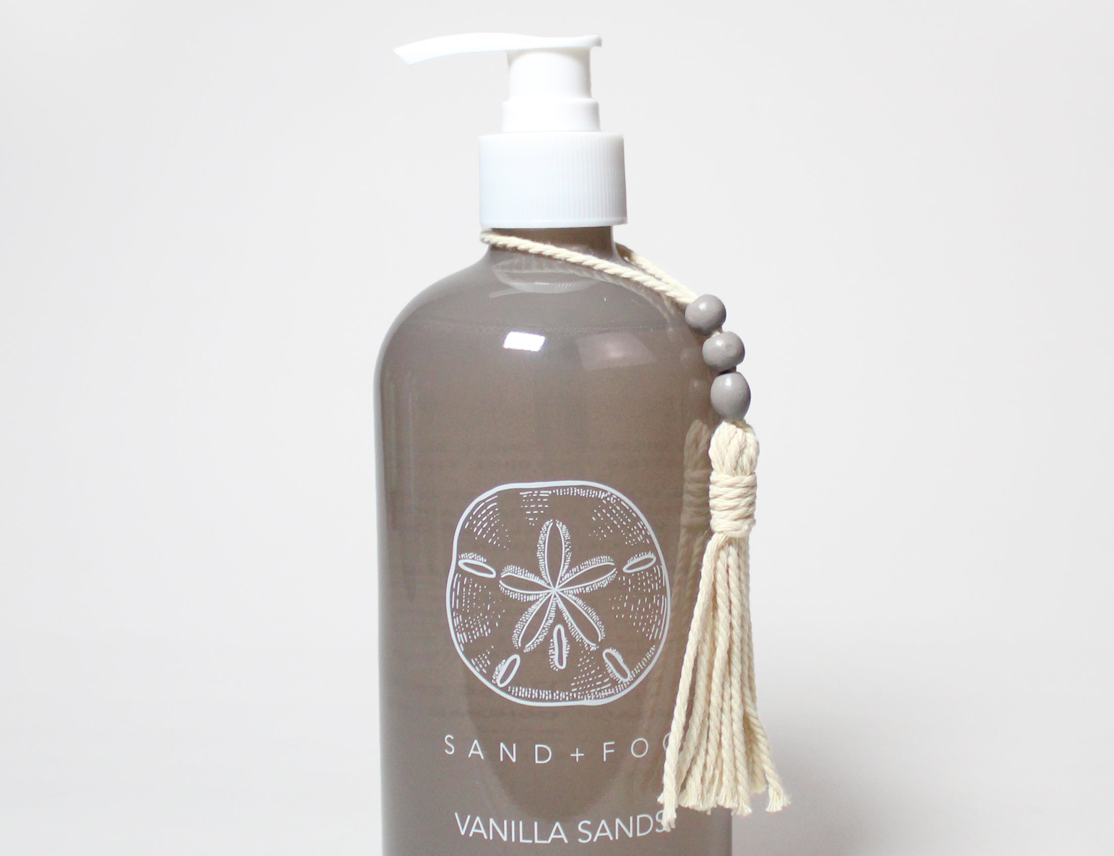 Dark brown liquid hand soap bottle with white pump and Vanilla Sands label