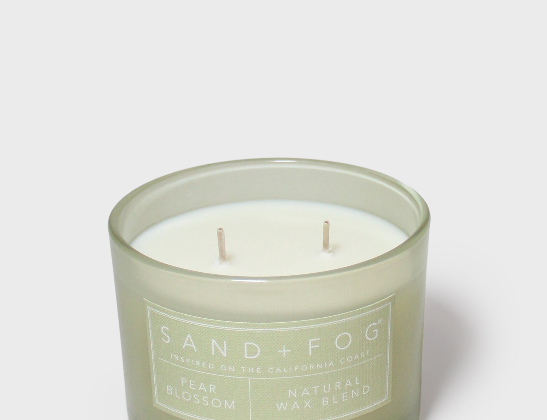 Sand + Fog pear blossom scented candle in green glass jar, two visible wicks