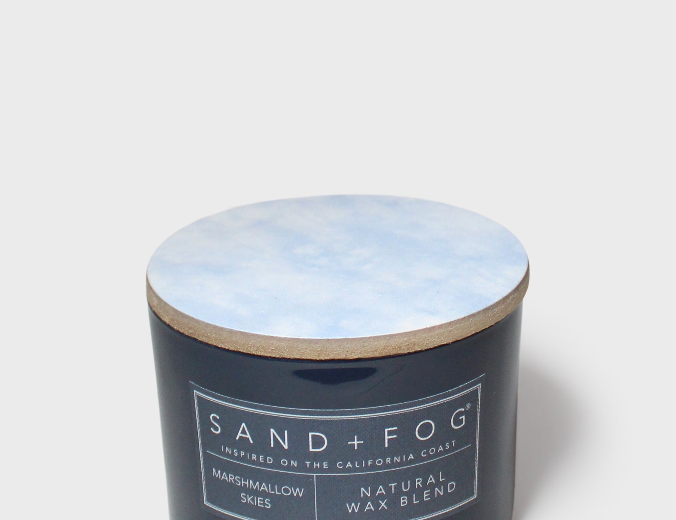 Scented candle in dark glass jar with wooden lid, cream label