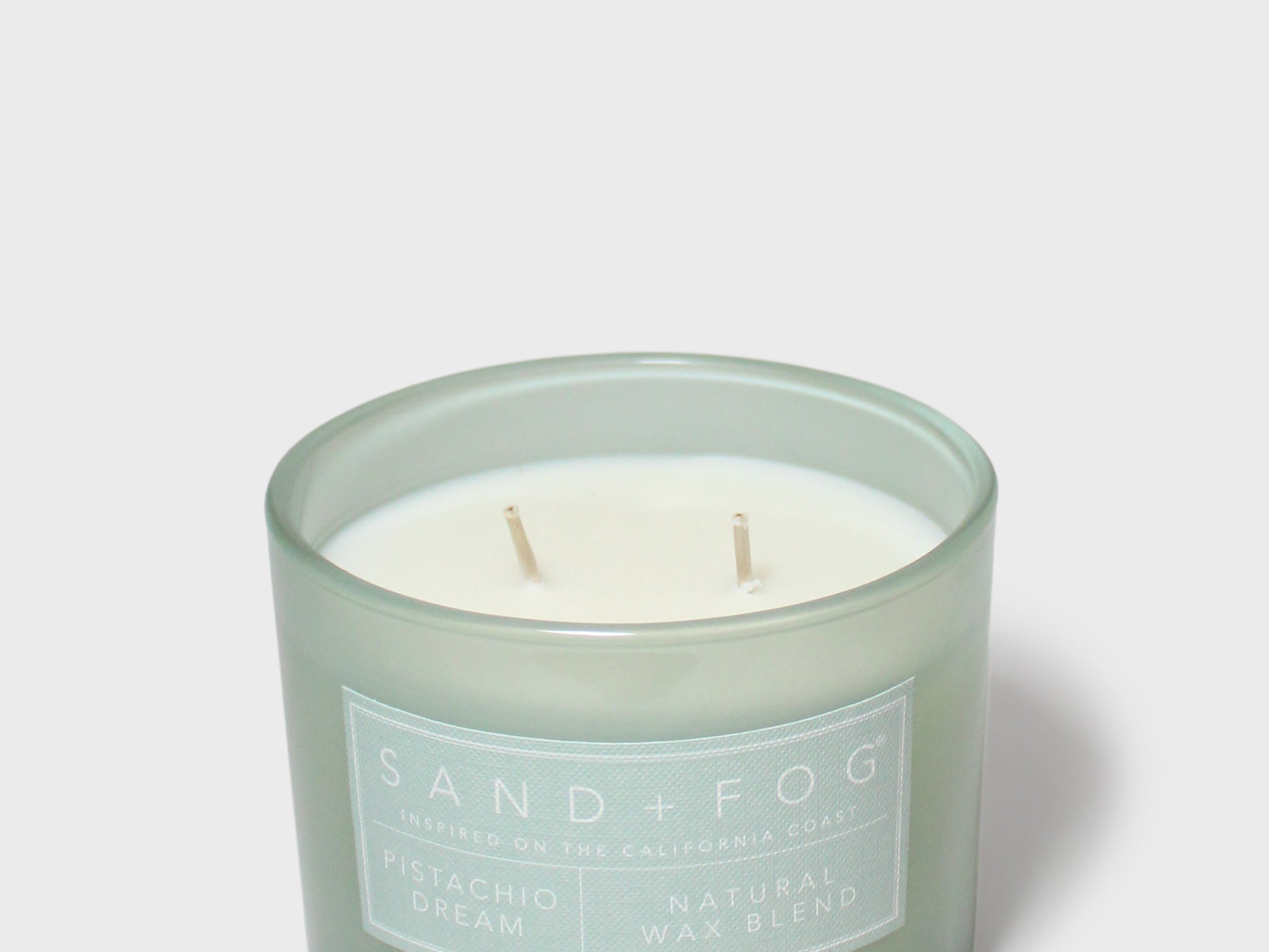 12 oz scented candle in frosted green jar with two wicks and visible wax