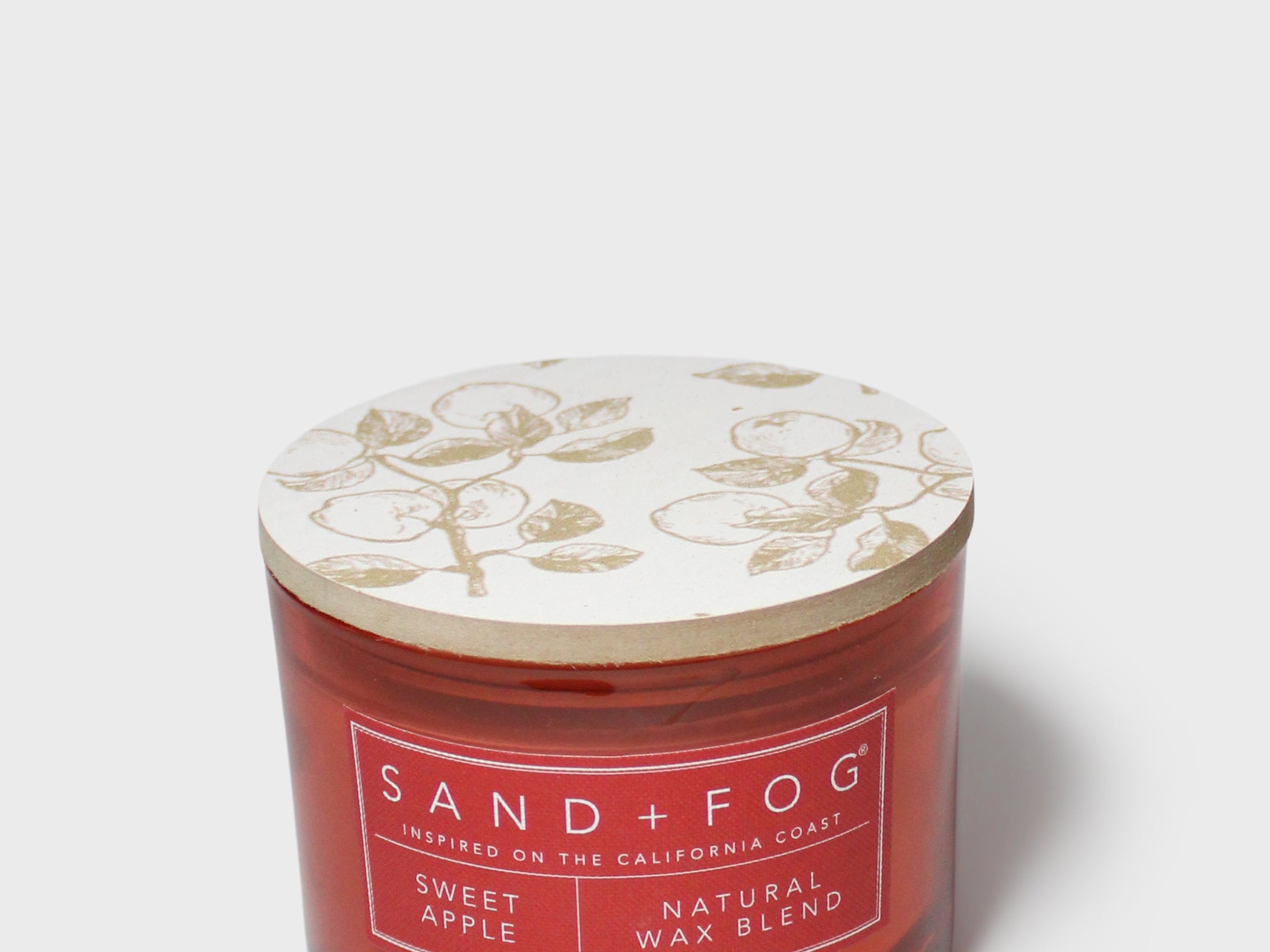 SAND + FOG Sweet Apple scented candle in red glass jar with patterned lid