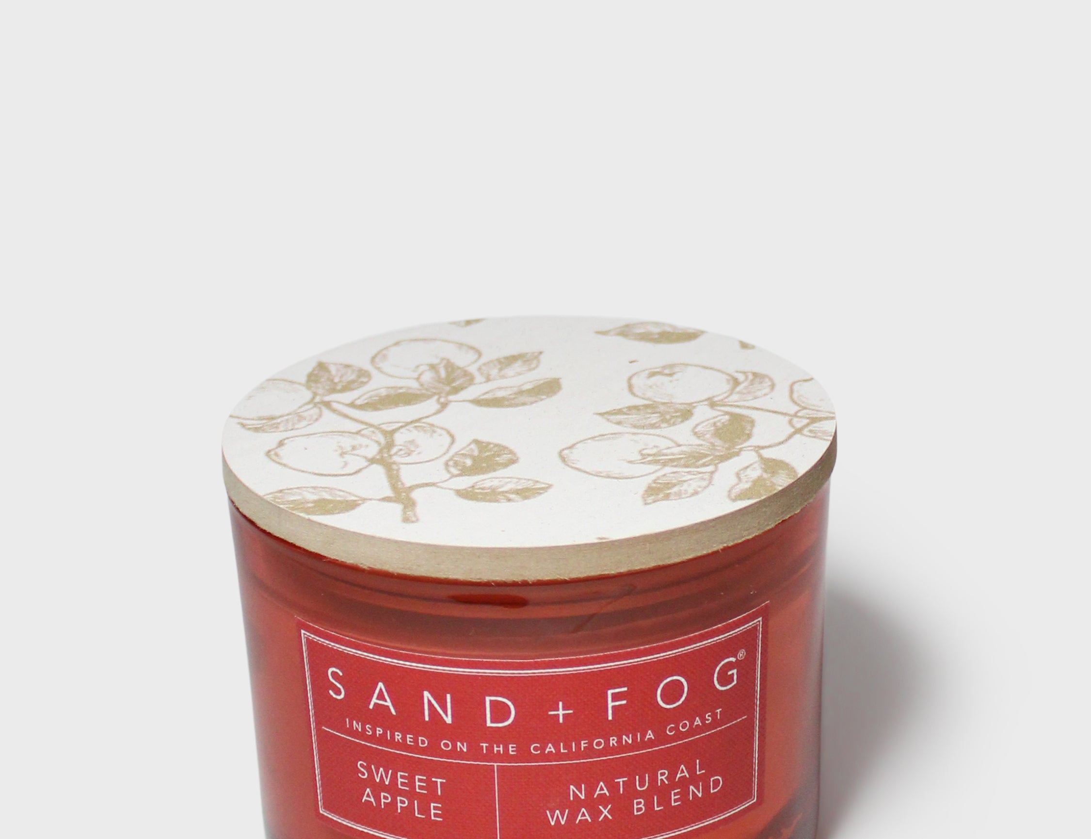SAND + FOG Sweet Apple scented candle in red glass jar with patterned lid