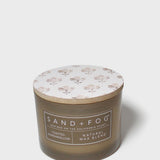 SAND + FOG scented candle in dark brown glass jar with floral lid
