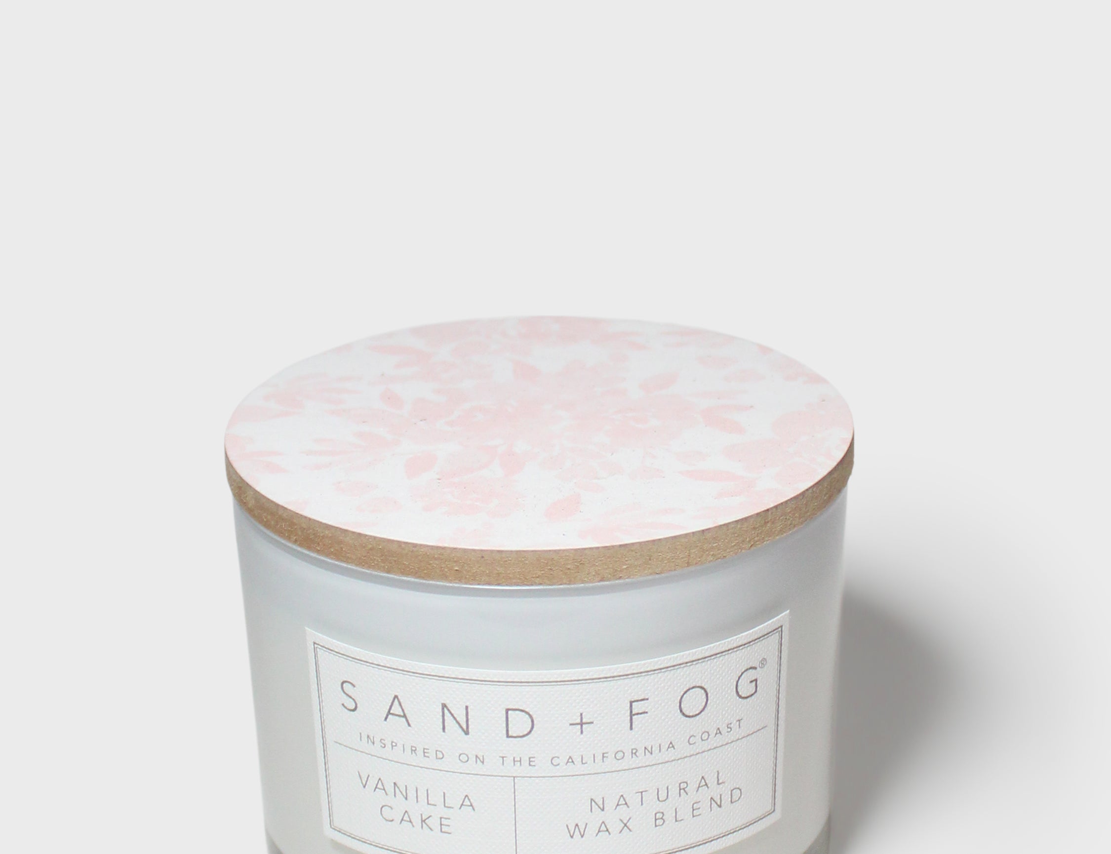 12 oz vanilla cake scented candle in glass jar, pale pink floral lid, Sand + Fog label