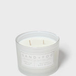 Glass jar scented candle, pale wax with two wicks, Sand+Fog label on front