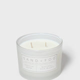 Glass jar scented candle, pale wax with two wicks, Sand+Fog label on front