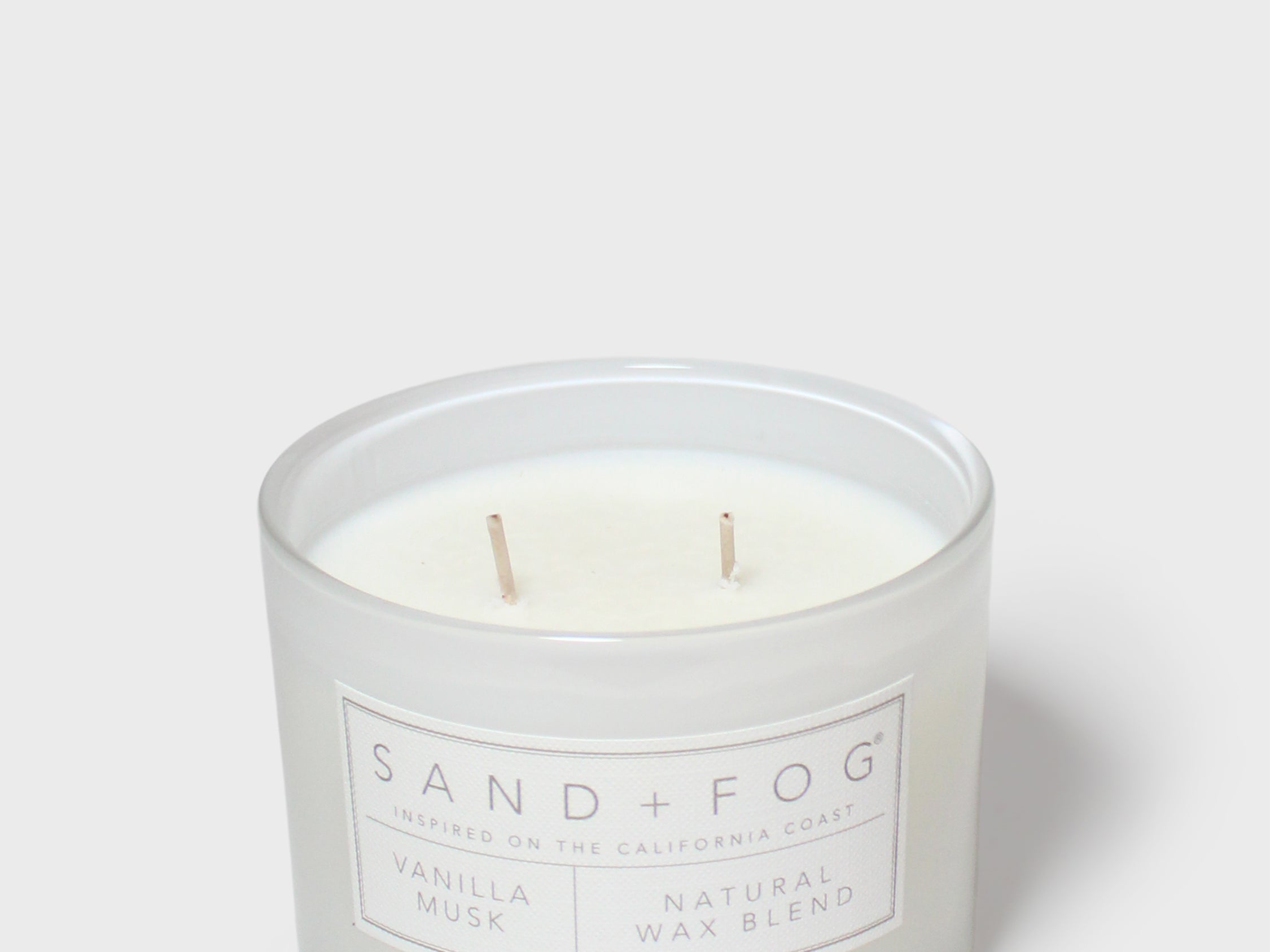 Glass jar scented candle, pale wax with two wicks, Sand+Fog label on front