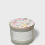 Scented jar candle, gray glass with Sand + Fog label and floral lid