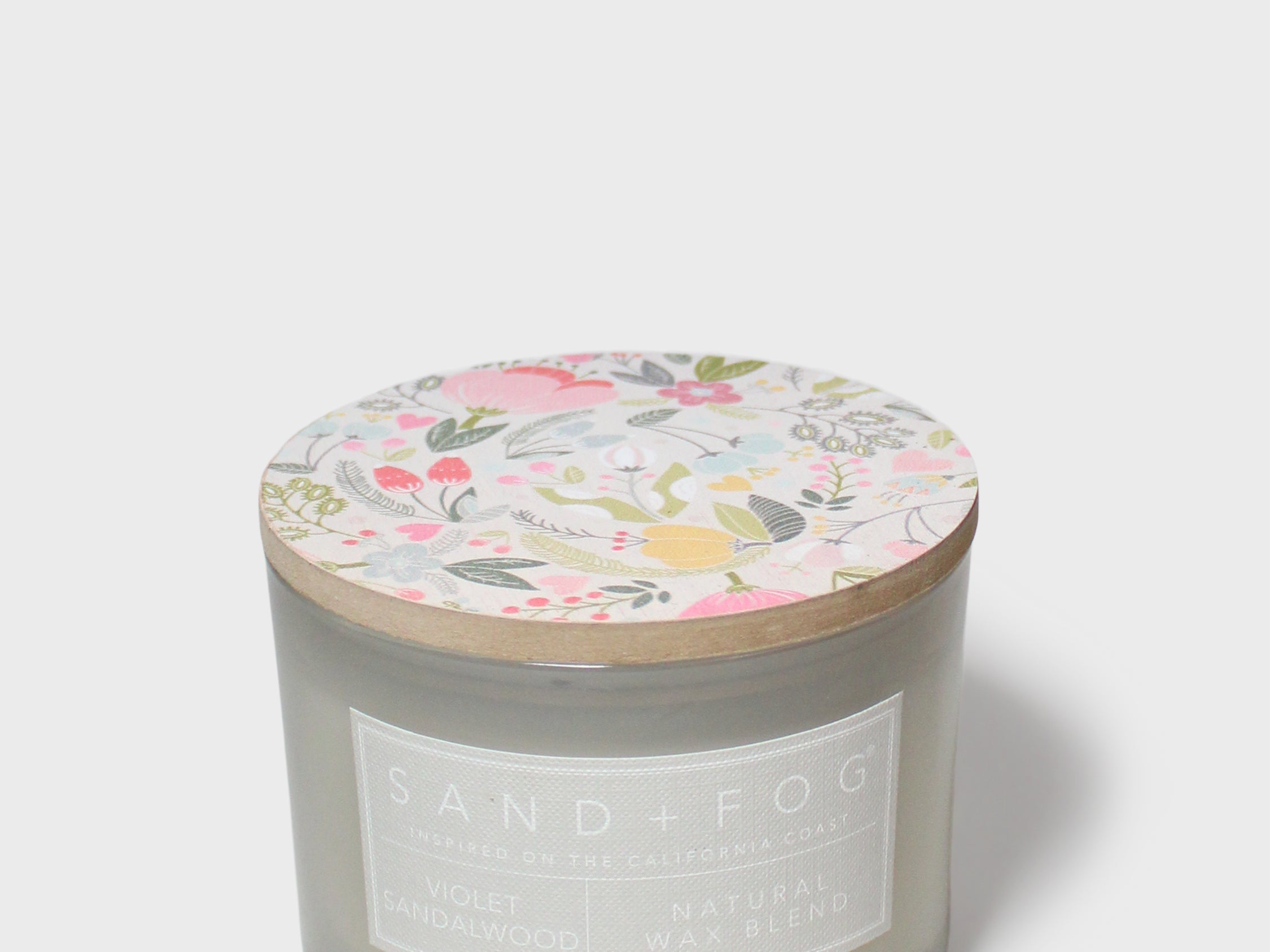 Scented jar candle, gray glass with Sand + Fog label and floral lid
