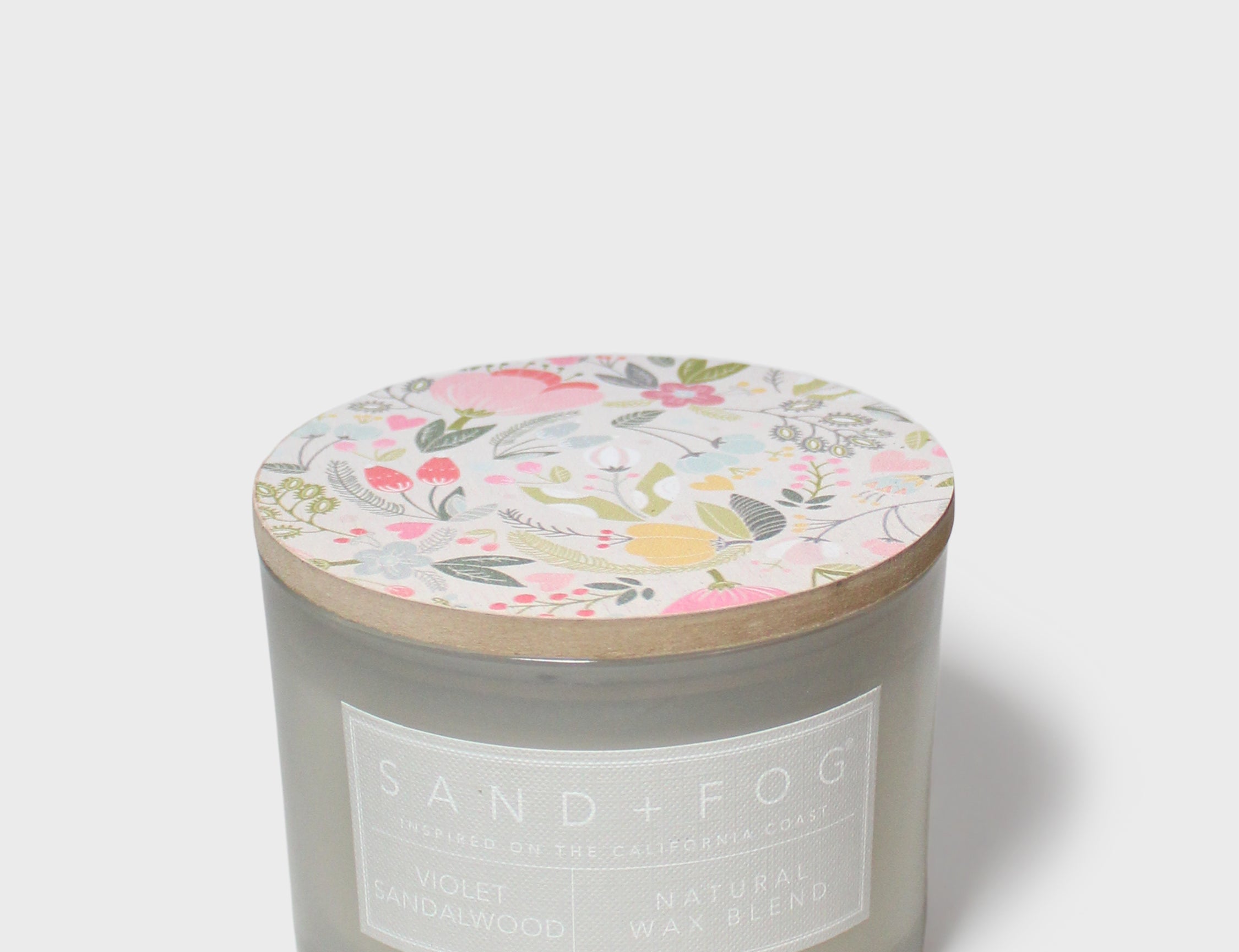Scented jar candle, gray glass with Sand + Fog label and floral lid