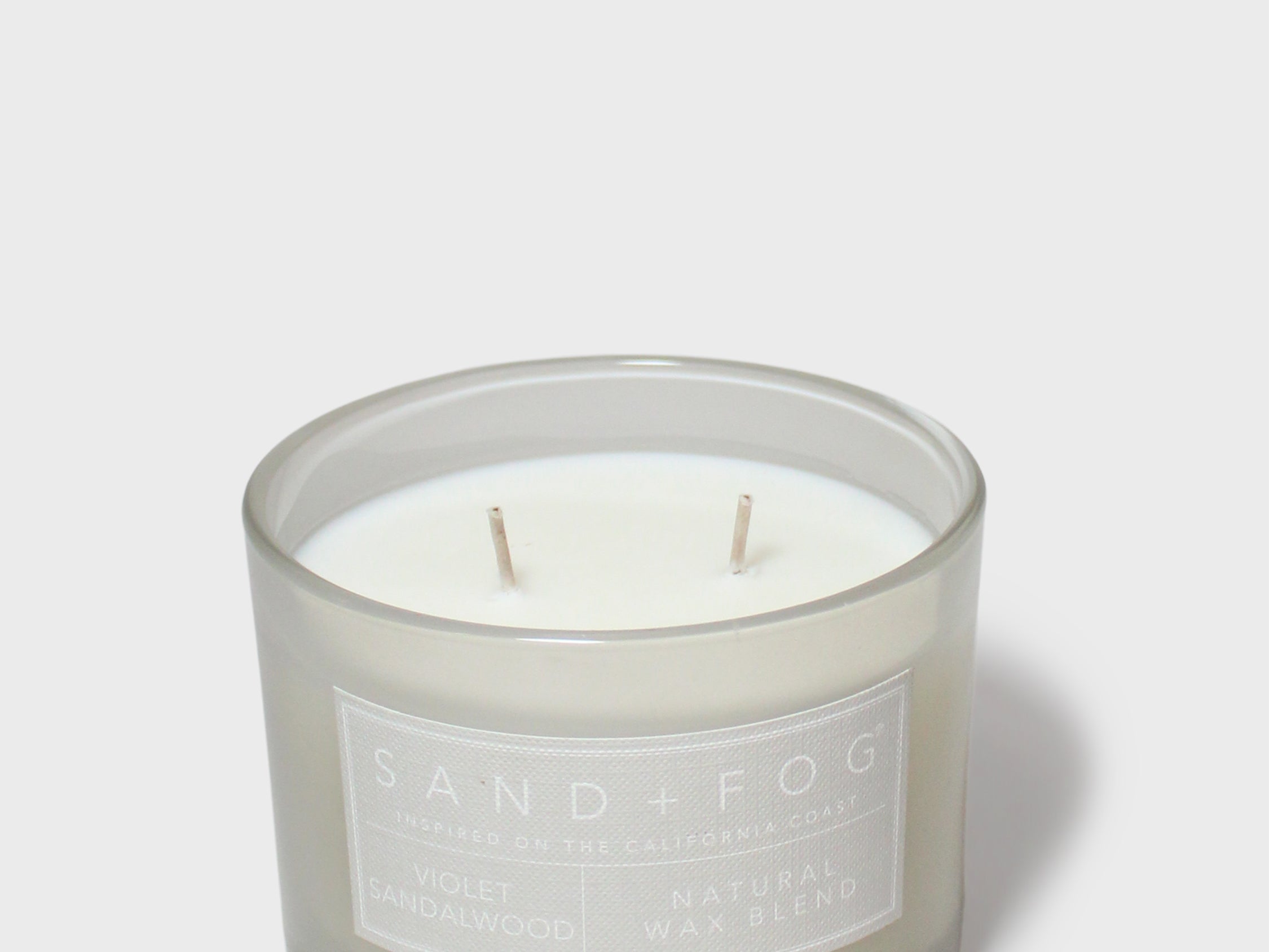 Scented jar candle with white wax and two wicks, gray glass, Sand + Fog label