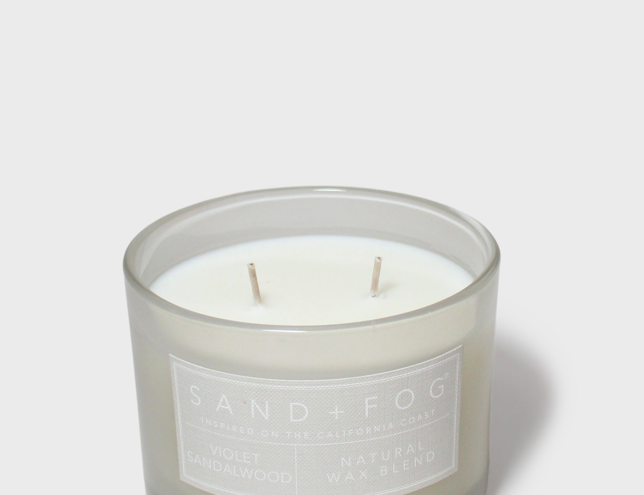 Scented jar candle with white wax and two wicks, gray glass, Sand + Fog label