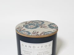 Scented candle in a navy jar with floral lid and white label