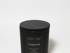 Matte black scented candle jar with flat lid top and centered label