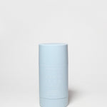Pale blue deodorant container with white cap and vertical label