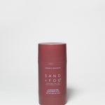 Burgundy deodorant stick with flat red cap, Sand + Fog label, 2.89 oz