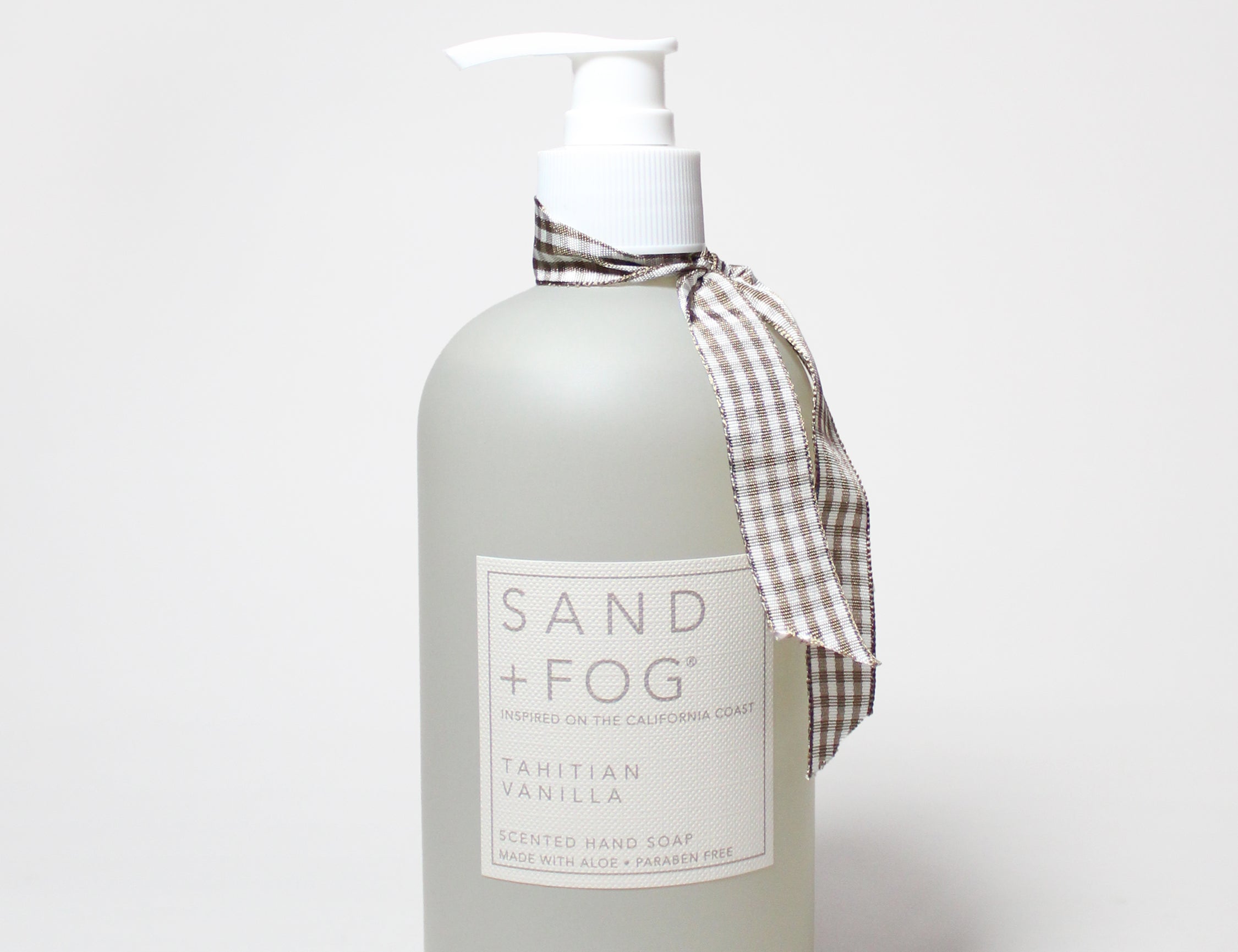 Matte white liquid hand soap bottle with white pump; beige plaid bow and label