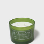 Green glass jar scented candle with white wax and Sand + Paws Forest label