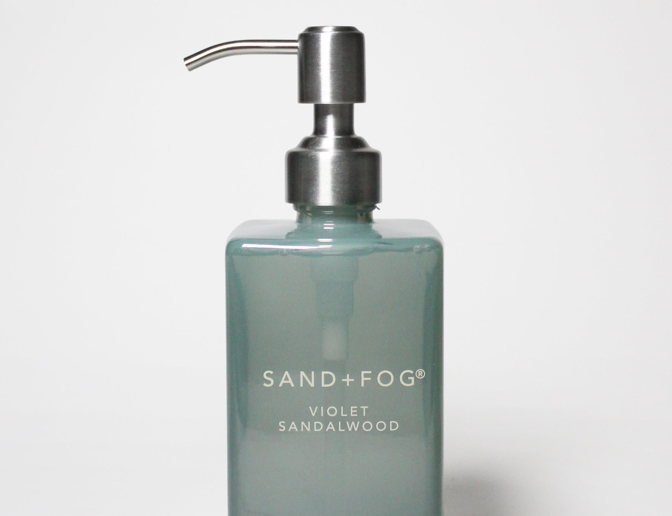 SAND+FOG liquid hand soap bottle with silver pump, teal glass and “Violet Sandalwood” label