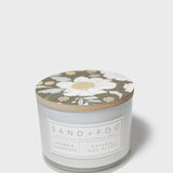 SAND+FOG scented candle with floral lid, natural wax blend label on jar