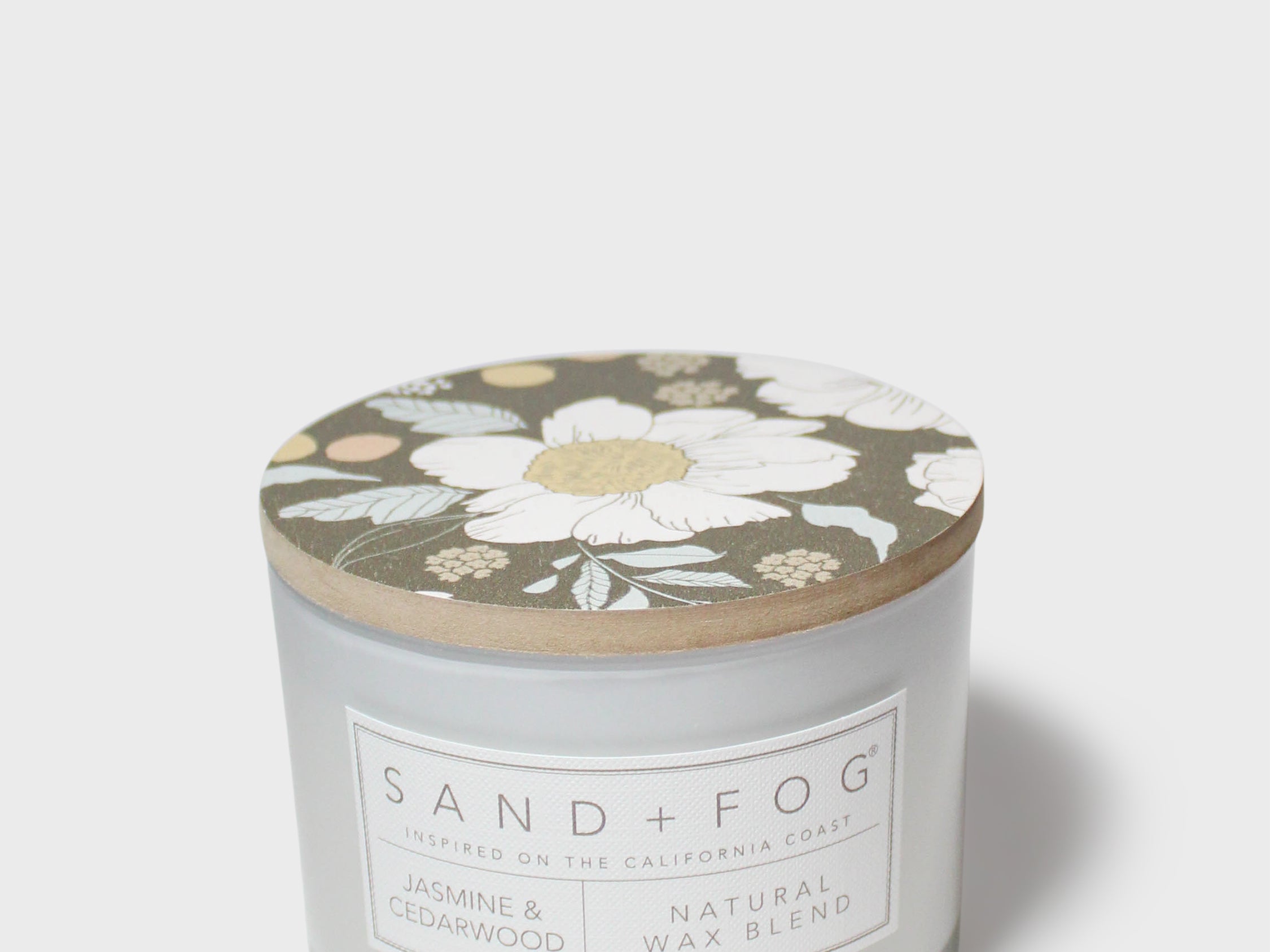 SAND+FOG scented candle with floral lid, natural wax blend label on jar