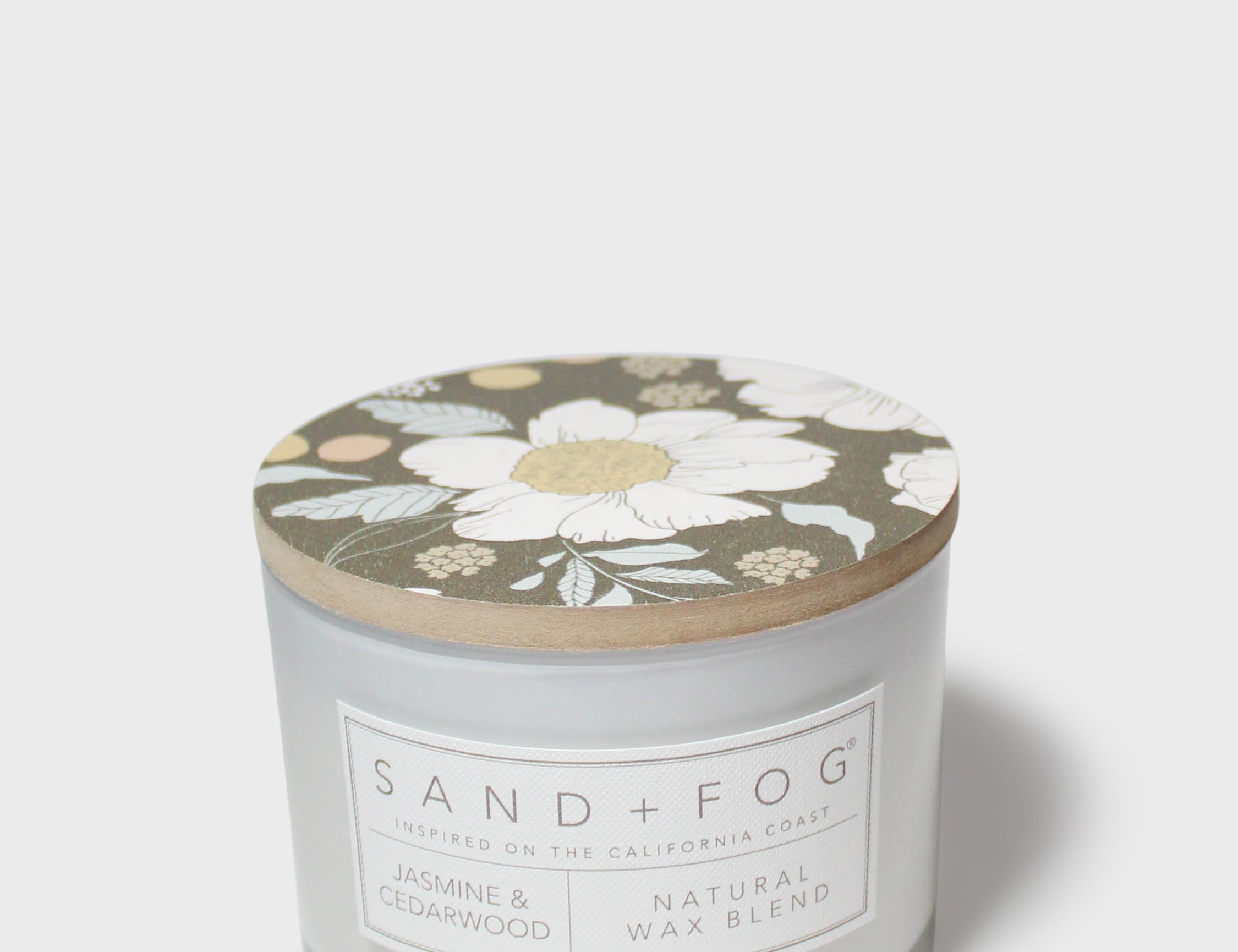 SAND+FOG scented candle with floral lid, natural wax blend label on jar