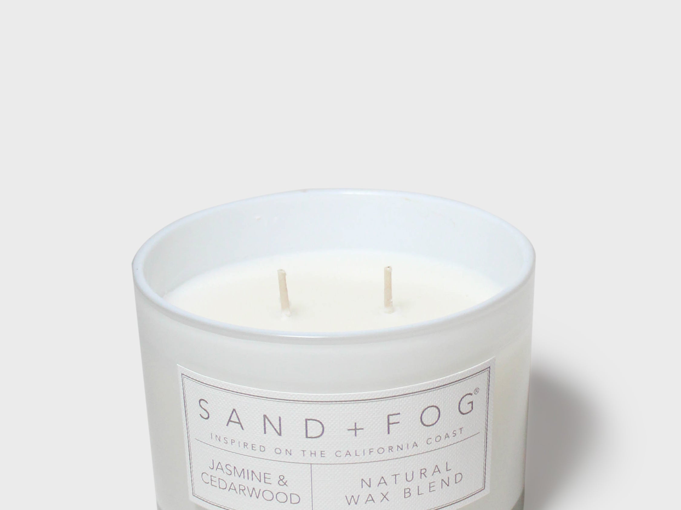 SAND+FOG scented candle in clear glass jar with two wicks, white label