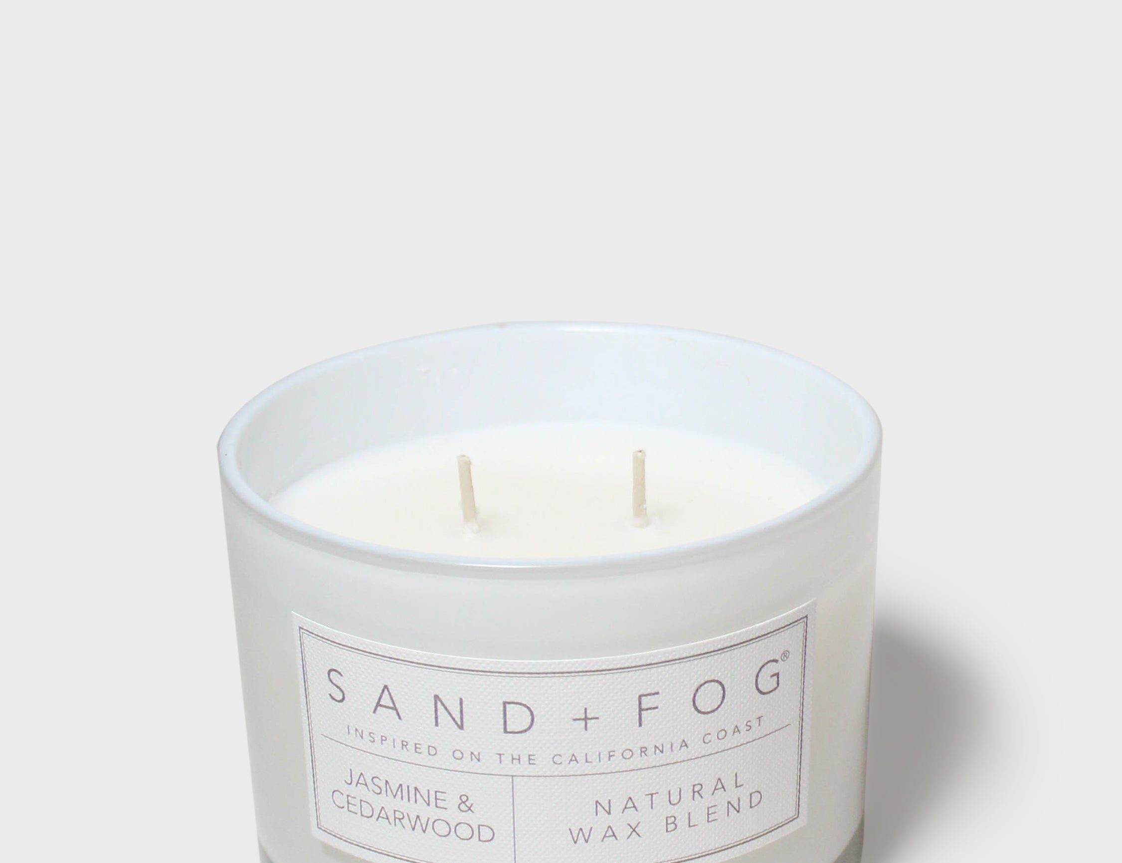SAND+FOG scented candle in clear glass jar with two wicks, white label