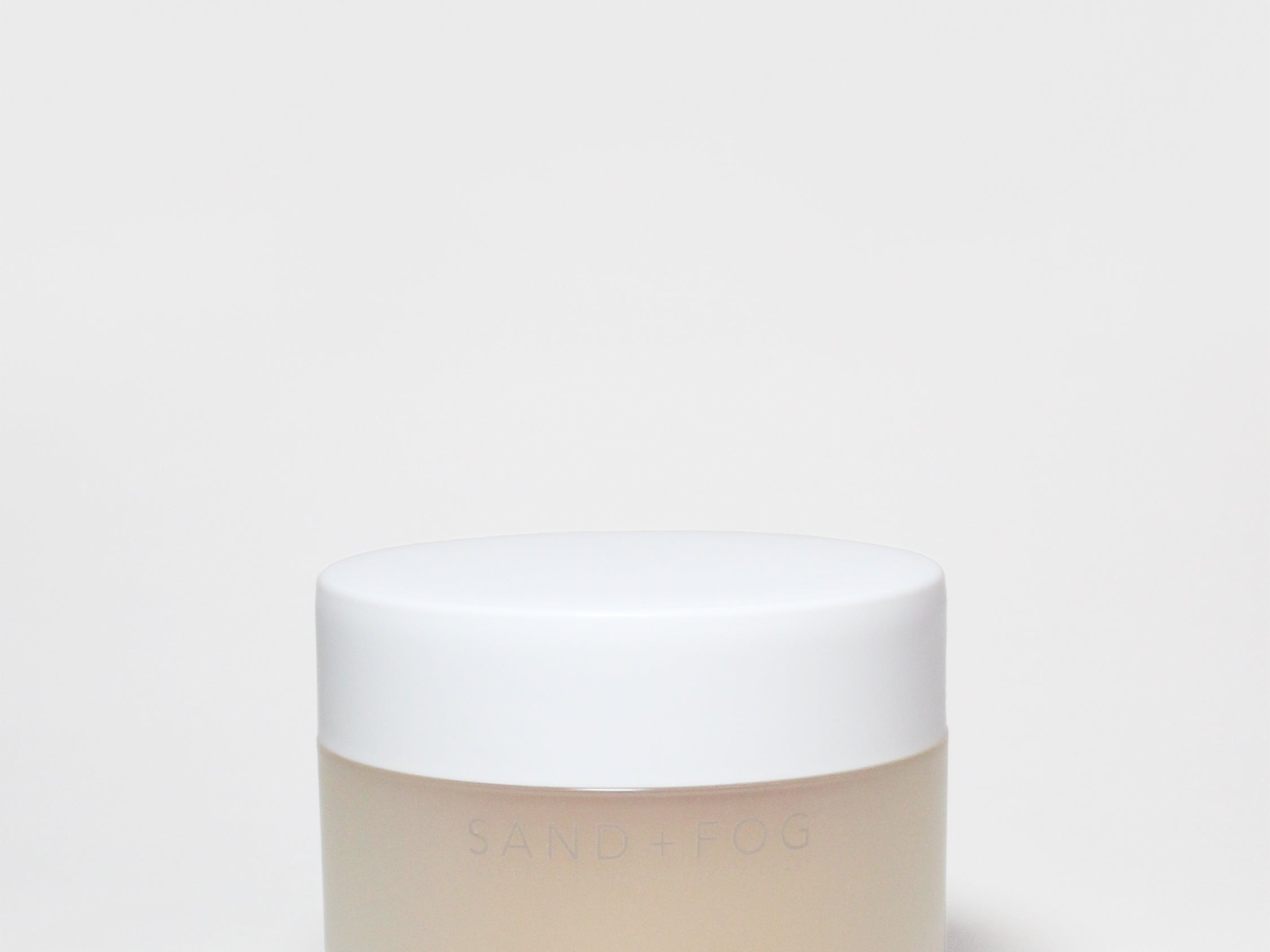Body scrub jar with white lid and creamy off-white scrub