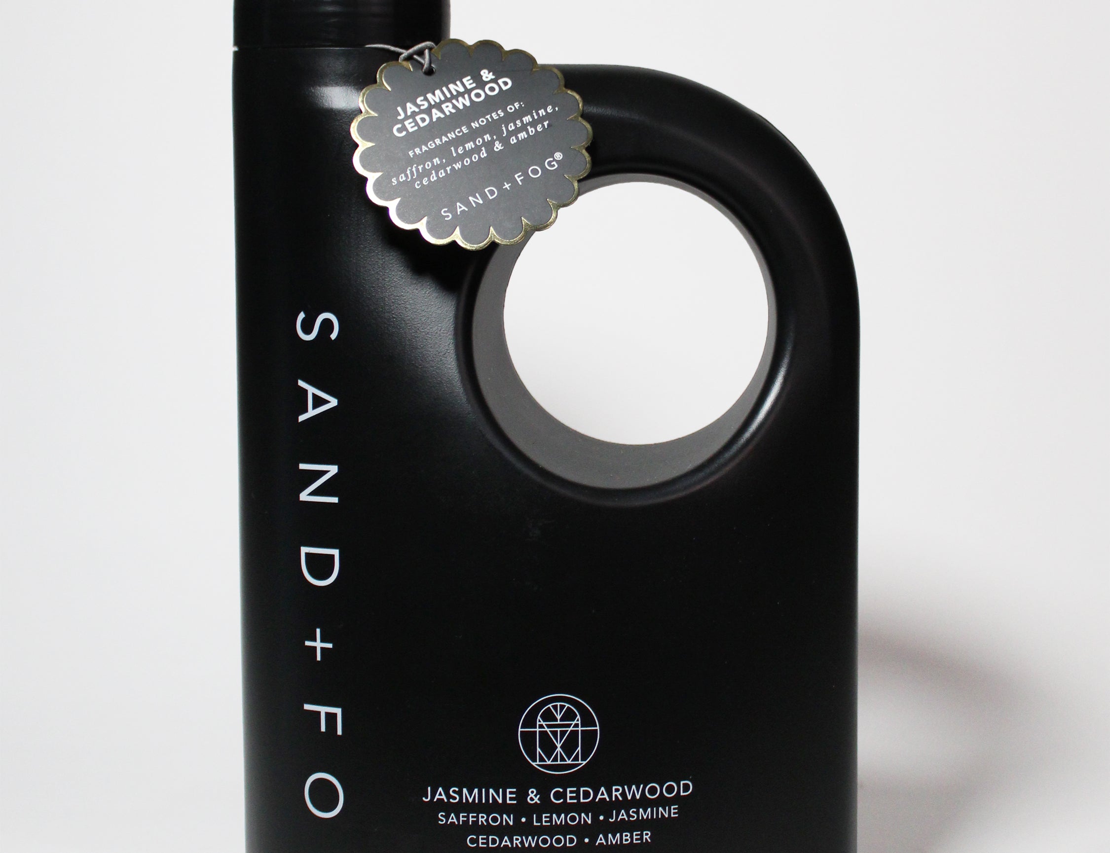 Black 2.1 liter laundry detergent jug with handle and jasmine cedarwood label