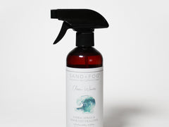 Fabric spray bottle with trigger nozzle, dark red liquid and white label