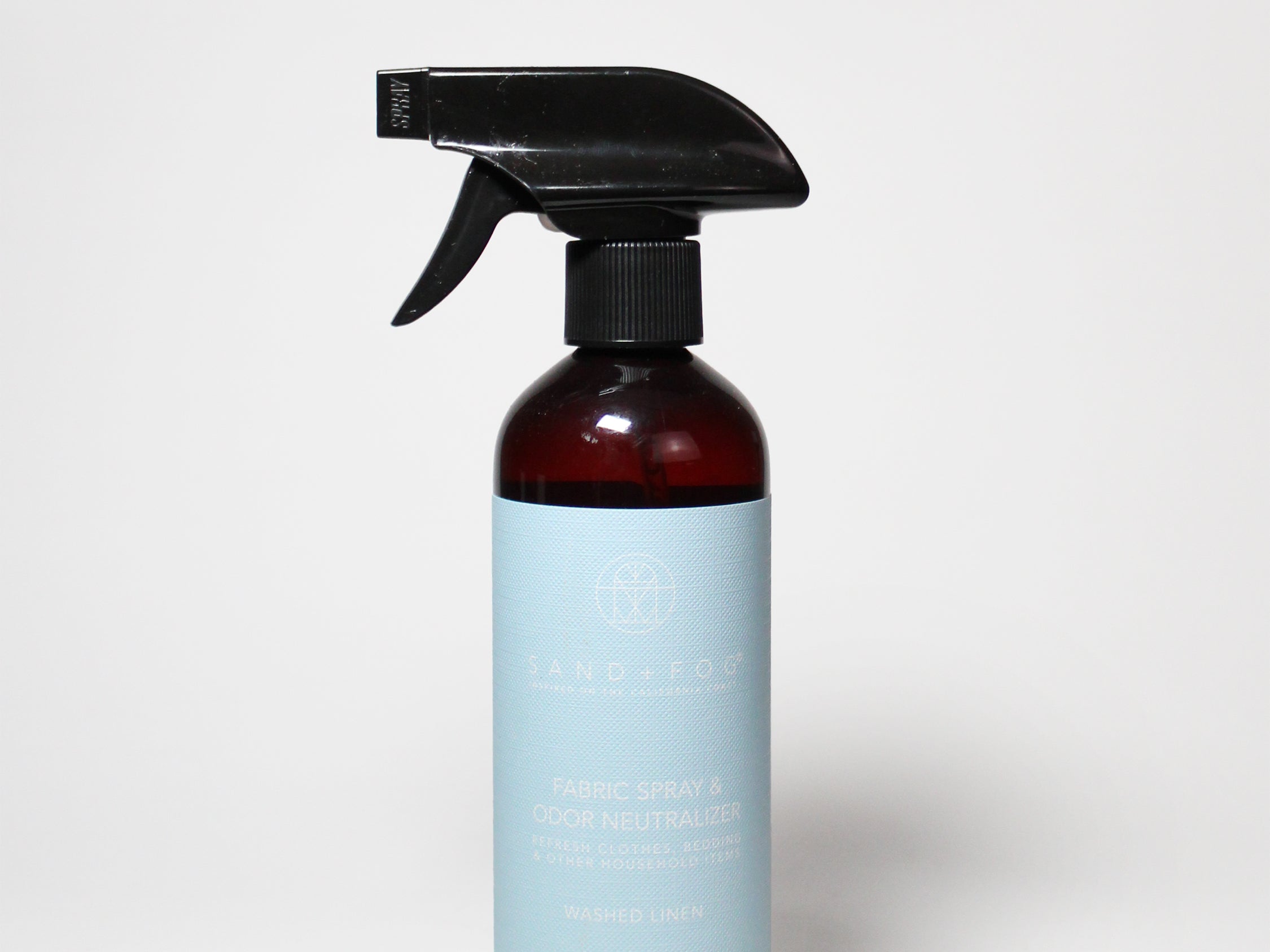 Washed linen fabric spray bottle with black trigger sprayer and amber liquid