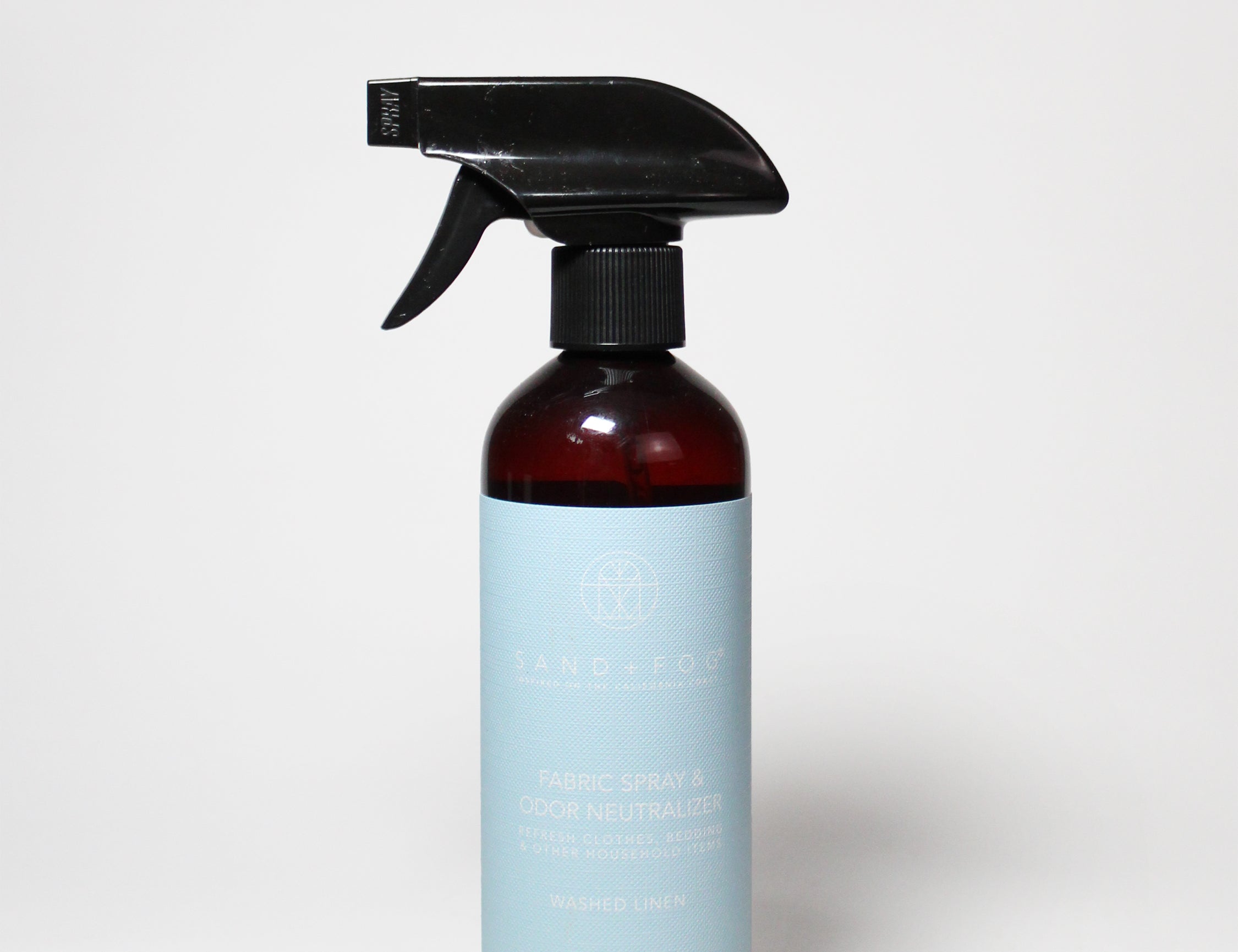 Washed linen fabric spray bottle with black trigger sprayer and amber liquid