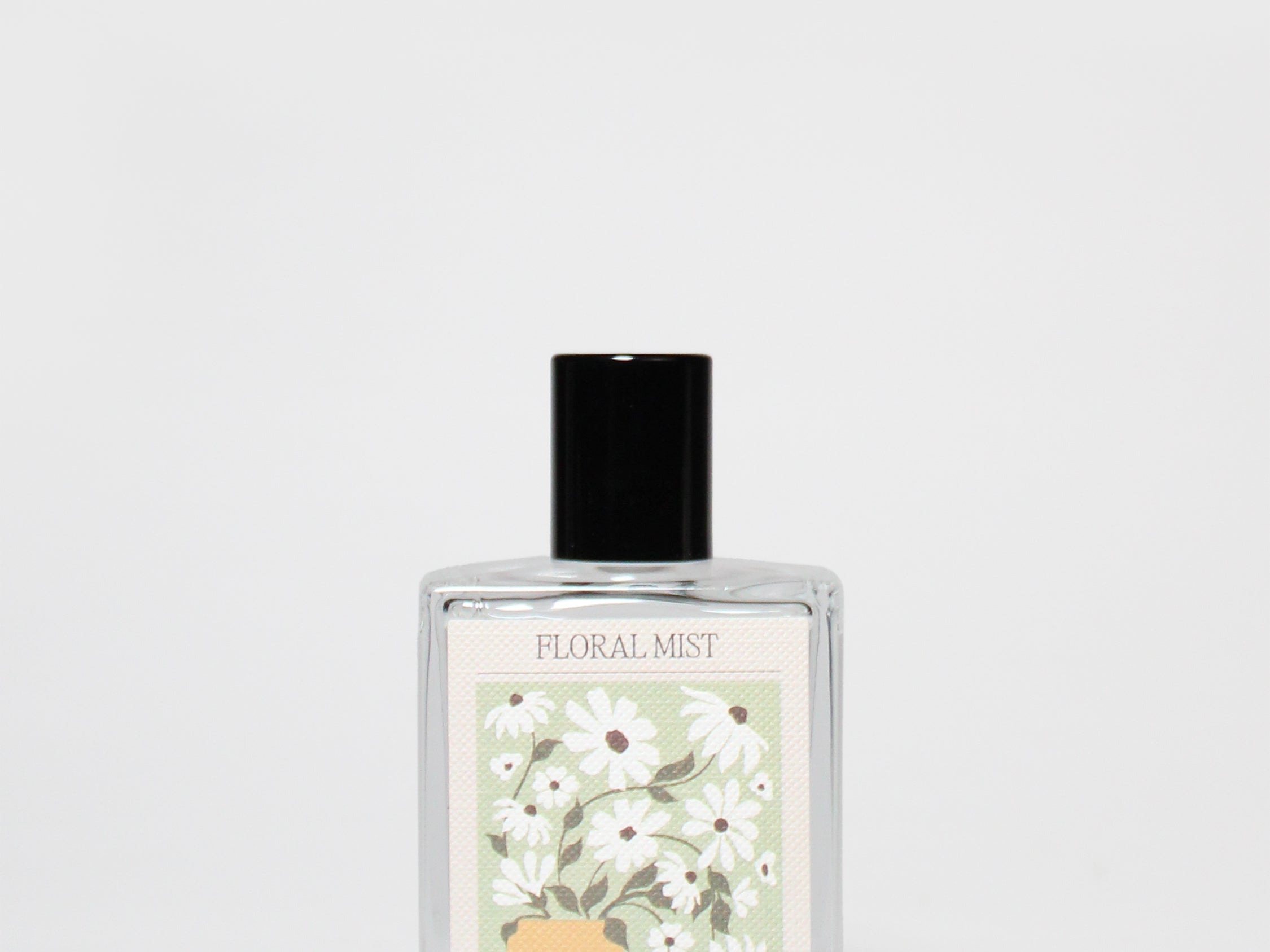 Floral mist perfume oil bottle with black cap and floral daisy label