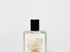 Perfume oil rollerball in clear glass bottle with black cap and floral label