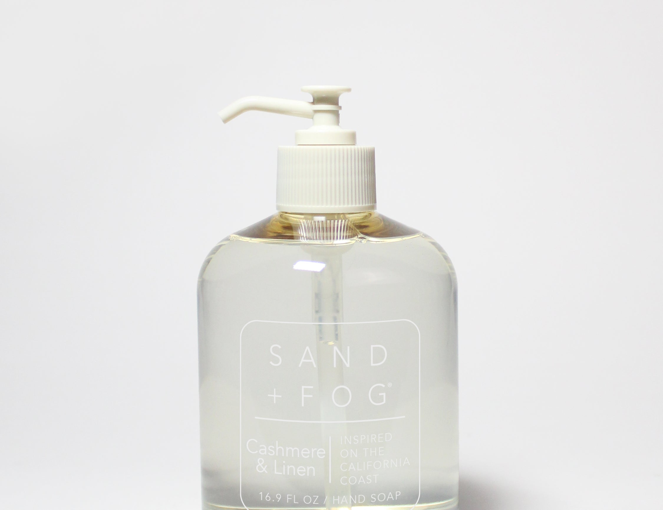Liquid hand soap bottle with white pump; clear amber liquid, Sand Fog label