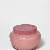 Pink embossed glass candle jar with its matching lid on top.