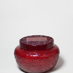 17 oz scented candle in a red embossed glass jar with a matching lid