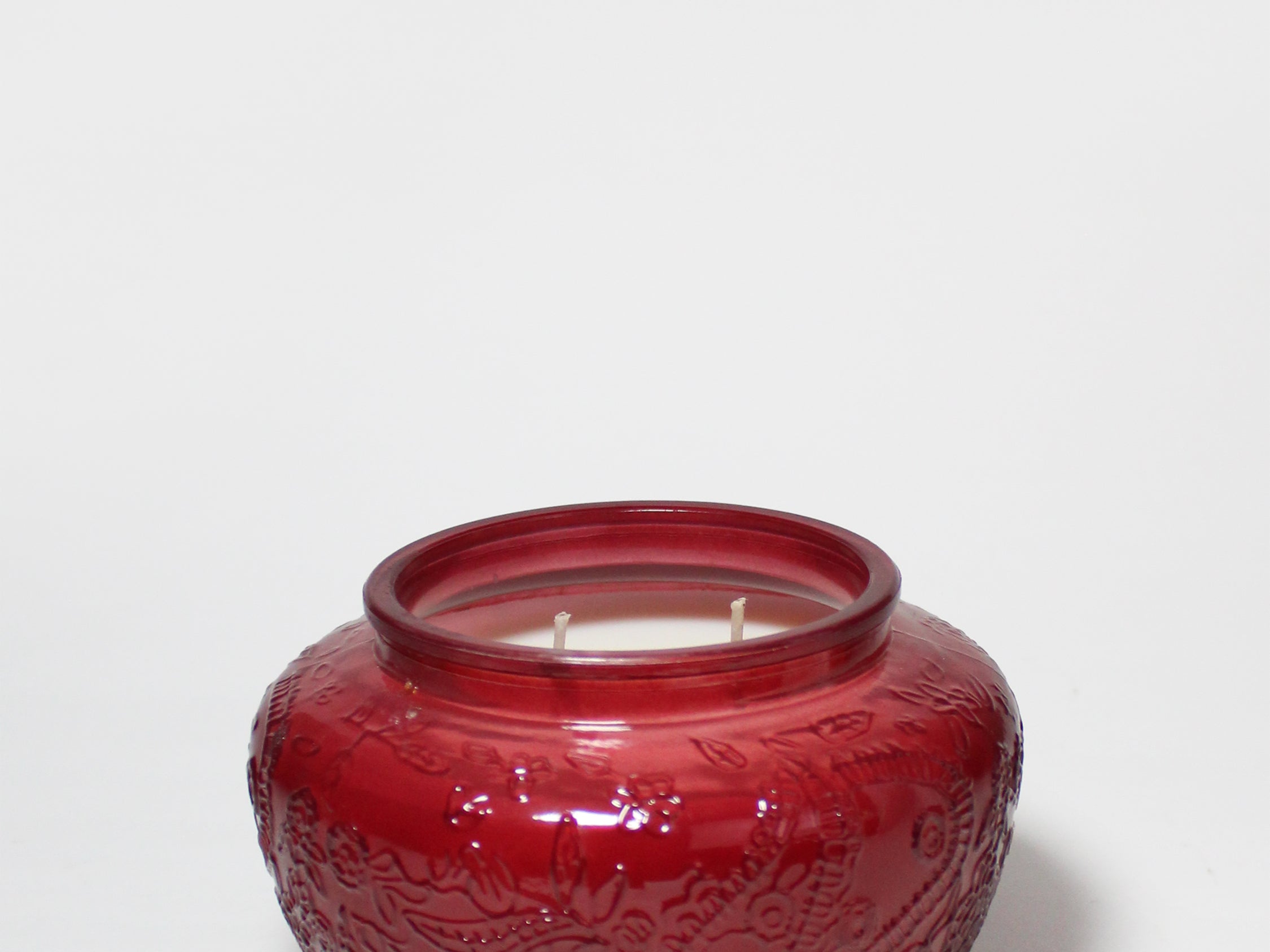17 oz scented candle in a red embossed glass jar with two wicks